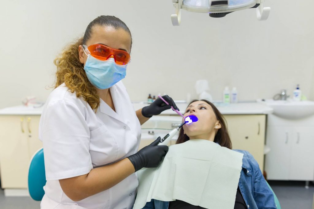 Adult female dentist treating patient in as part of sedation Dentistry NYC